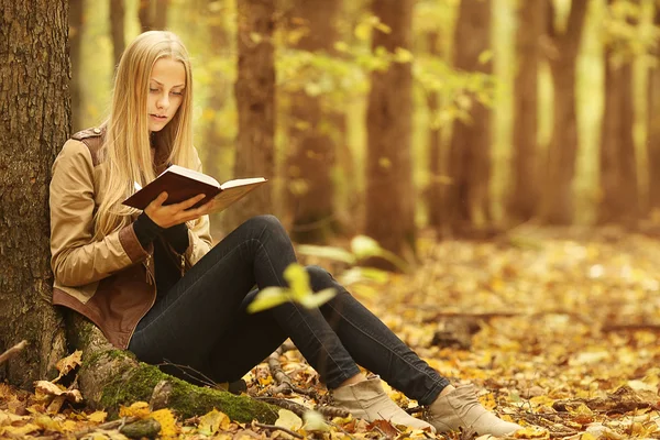 Young beautiful girl with a book in the autumn forest — Stock Photo, Image