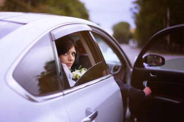 Ritratto della sposa a un matrimonio seduto in macchina — Foto Stock