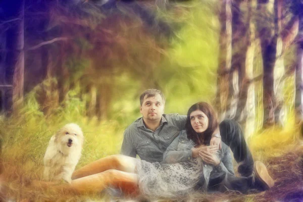 Young man and woman outdoors playing with a small dog — Stock Photo, Image