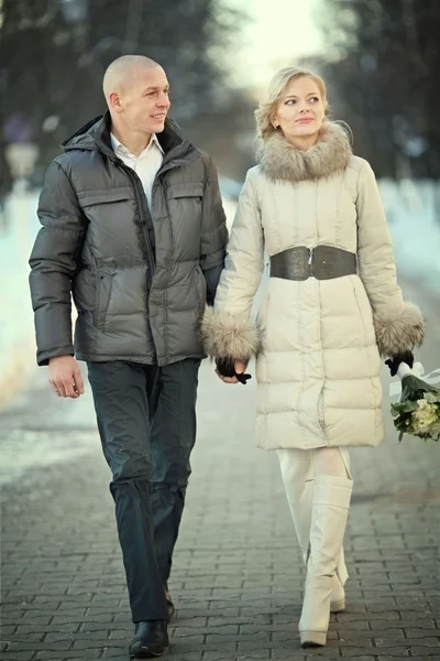 男人和女人走在冬天举办的婚礼在大街上 — 图库照片