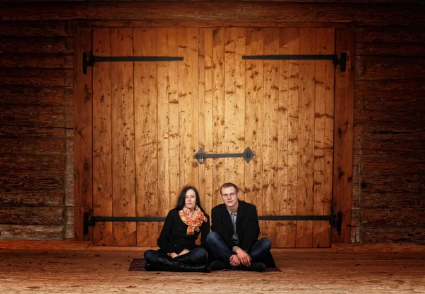 Joven hombre de familia y una mujer en una casa de madera rústica — Foto de Stock