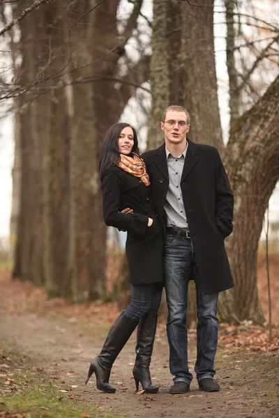 Unga älskande man och kvinna i skogen höst — Stockfoto