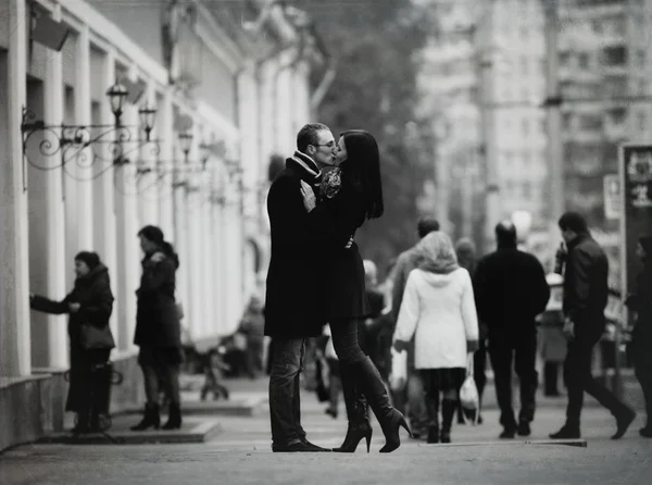 Liebespaar küsst und kuschelt auf einer Straße in der Stadt mit Passanten — Stockfoto