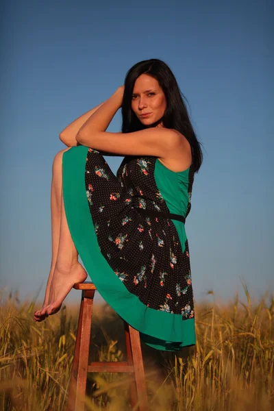 Hermosa chica con un taburete en el campo —  Fotos de Stock