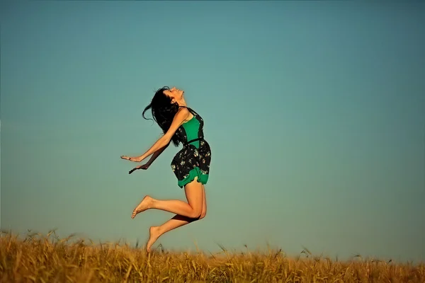 Hermosa joven saltando en el campo — Foto de Stock