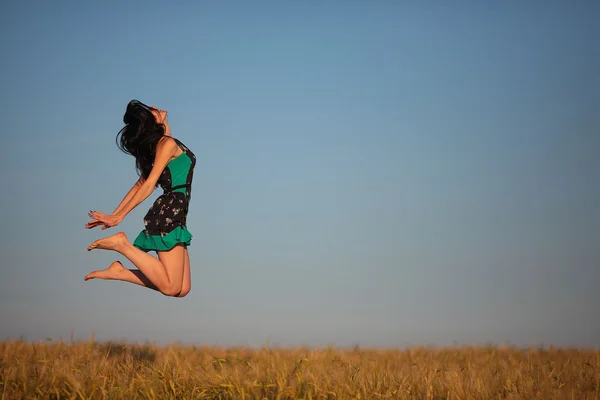 美しい少女は、フィールドにジャンプ — ストック写真