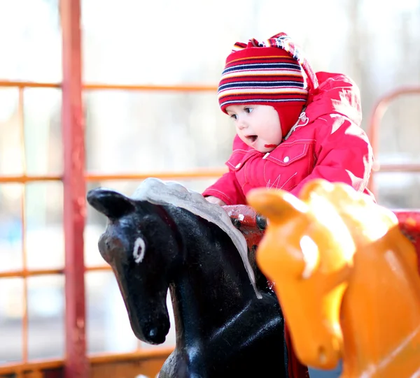 Pequena menina alegre 2-3 anos, jogando no carrossel — Fotografia de Stock