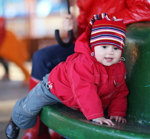 Kleines fröhliches Mädchen 2-3 Jahre, das auf dem Karussell spielt — Stockfoto