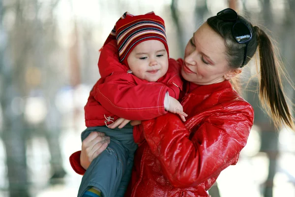 Moeder spelen met haar baby buiten in de winter — Stockfoto