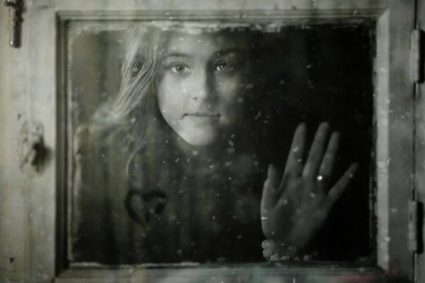 Porträtt av en flicka utanför fönstret — Stockfoto