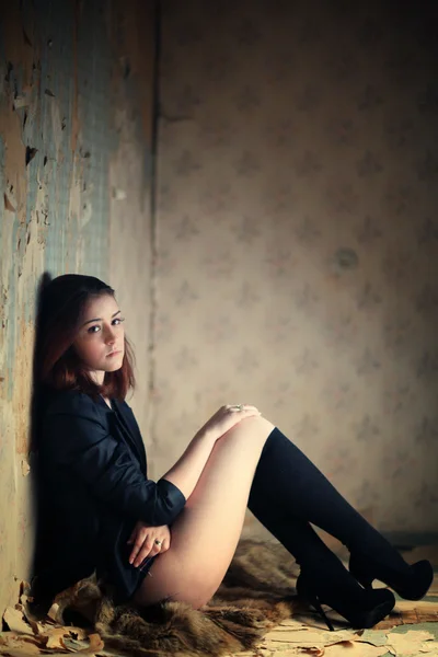 Donna stressata con le gambe nude si siede e fuma in una vecchia casa — Foto Stock