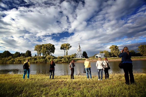 Tourists looking at the church on a river — Stock Photo, Image