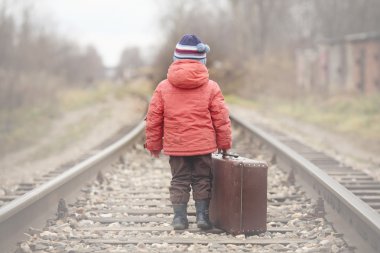 Little traveler with a suitcase on the railroad clipart