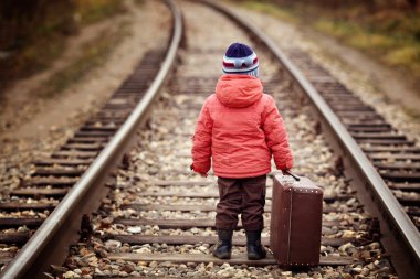 Little traveler with a suitcase on the railroad clipart