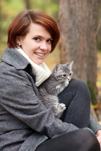 女孩和一只猫在片秋色的公园 — 图库照片