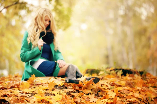 Trauriges Mädchen Herbstblätter in einer Unschärfe — Stockfoto