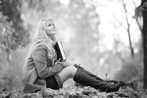 Ragazza che legge un libro nel parco autunnale — Foto Stock