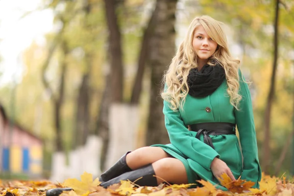 Triste fille assis sur des feuilles jaunes — Photo