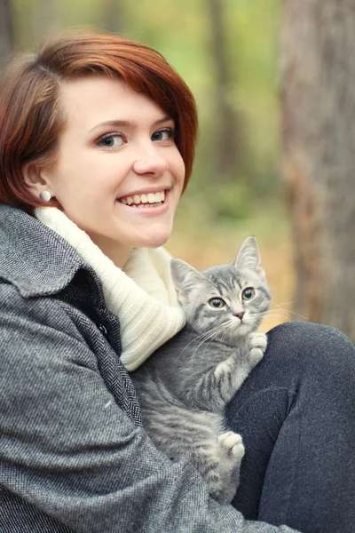 女孩和一只猫在片秋色的公园 — 图库照片