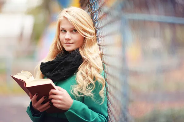 Mädchen liest im Herbstpark ein Buch — Stockfoto