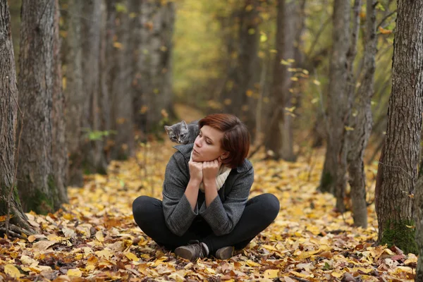 Mädchen und eine Katze im Herbstpark — Stockfoto