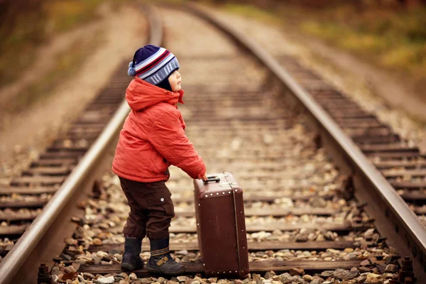 Little traveler with a suitcase on the railroad — Stock Photo, Image
