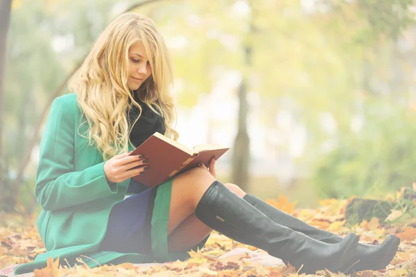 Дівчина читає книгу в осінньому парку — стокове фото