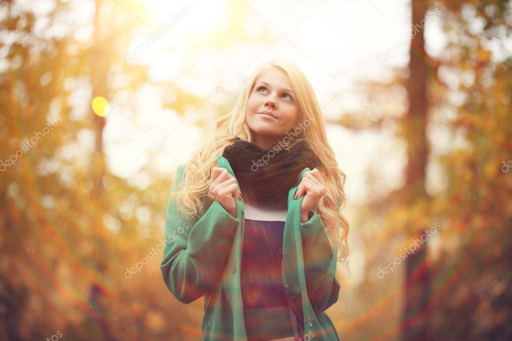 Beautiful happy blond woman in autumn park
