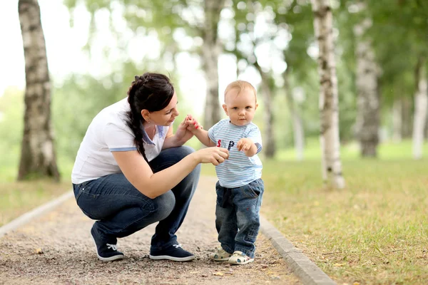 Felice giovane madre che gioca con il bambino nel parco — Foto Stock