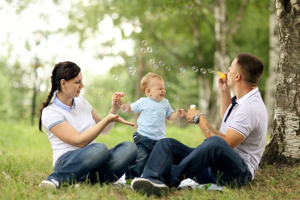 Gelukkig jonge moeder spelen met baby in het park — Stockfoto