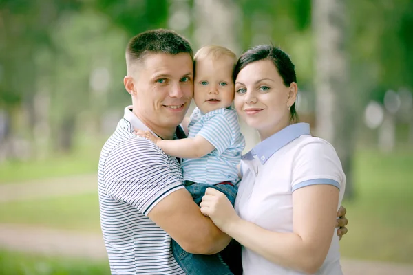 Feliz joven familia mamá papá y bebé en el parque —  Fotos de Stock