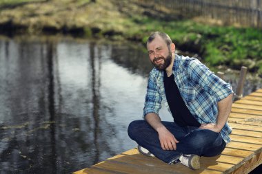 İskele üzerinde oturan adam