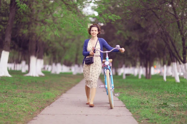 Девушка с велосипедом в парке — стоковое фото