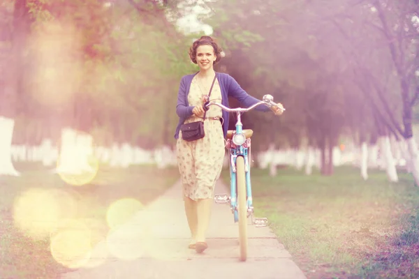 Chica con bicicleta en el parque — Foto de Stock