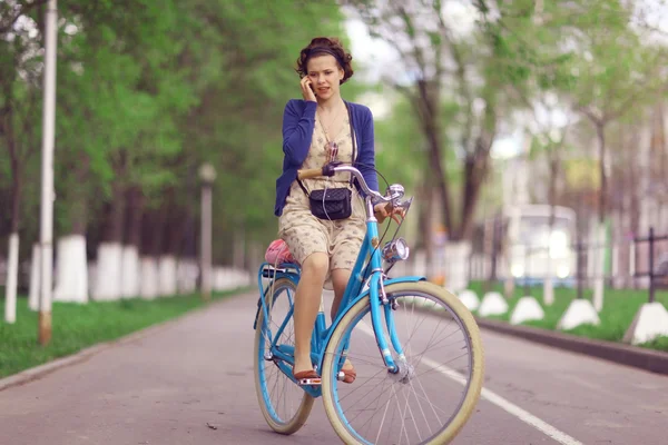 Mujer con teléfono en bicicleta — Foto de Stock