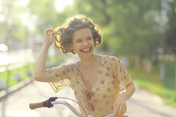 Счастливая девушка с велосипедом — стоковое фото