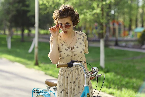 Chica curiosa con bicicleta —  Fotos de Stock