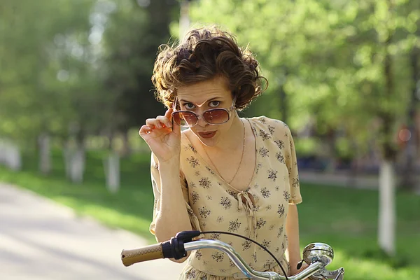 Любопытная девушка с велосипедом — стоковое фото