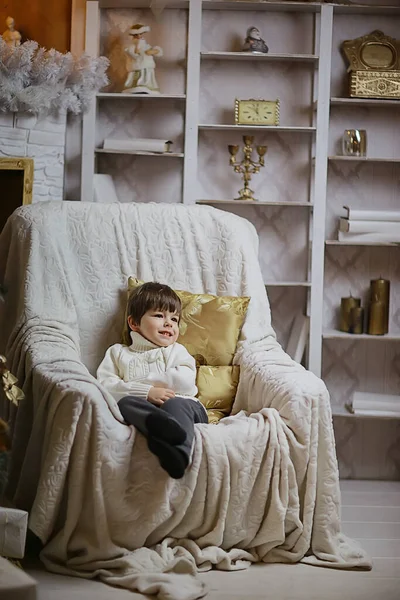 少年は椅子に座って新年のインテリアスタジオで — ストック写真