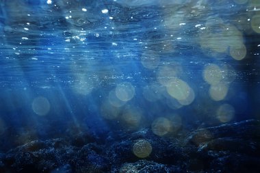 Suyun altında güneş ışınları mavi okyanus arka planı, su duvar kağıdındaki soyut güneş ışığı