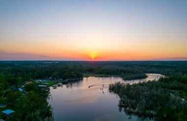 Gün batımında nehirdeki bir teknenin havadan görüntüsü. 