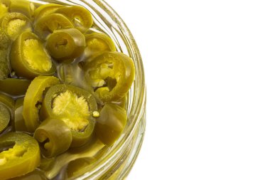 Beyaz arka planda izole edilmiş cam bir kavanozda jalapeno biberi dilimlenmiş. Fotokopi alanı olan yemek arka planı. Üst görünüm