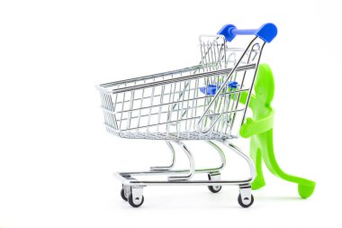 Yeşil plastik oyuncak soyut adam boş alışveriş arabalarını itiyor. Süpermarketlerde ve alışveriş merkezlerinde alışveriş zamanı. Tatil satış kavramı.
