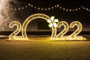 Krasnoyarsk, Rusya - 30 Aralık 2021: 2022 gecesi ışıl ışıl altın sayılar. Noel ve Mutlu Yıllar 2022 sokak süslemeleri.