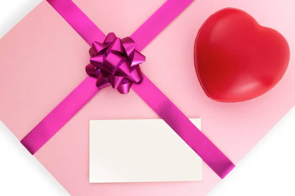 粉红礼品盒上的空白白色名片 白色背景上有品红蝴蝶结和彩带 3月8日 母亲节 情人节或生日的节日背景 顶部视图 — 图库照片