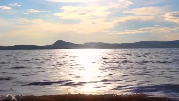 水面に太陽のまぶしさ 湖での小さな波 湖の夏の日 水面に反射する太陽 — ストック動画