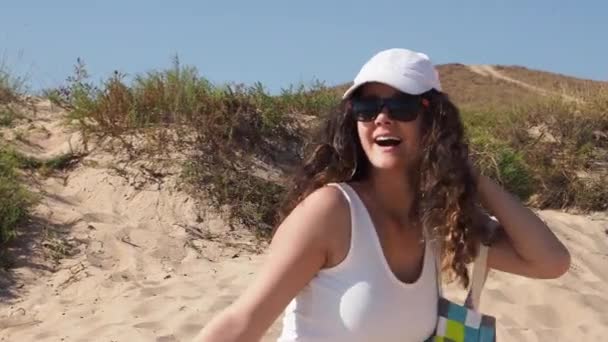 戴着太阳镜和帽子在海滩上散步的少女 — 图库视频影像
