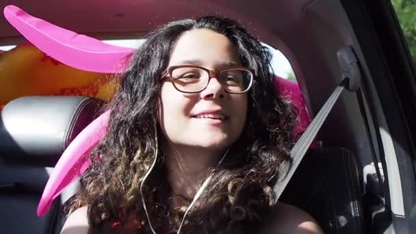 镜头中的卷曲少女戴着眼镜坐在移动的汽车里 — 图库视频影像