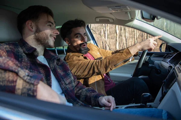 Dois Amigos Sexo Masculino Dirigindo Carro Mostrando Algo Enquanto Dirige — Fotografia de Stock