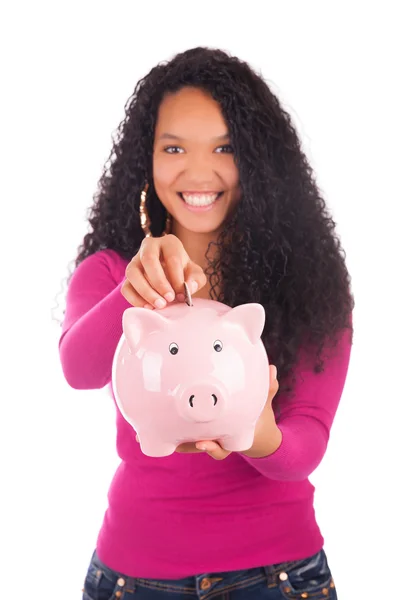 Young african american woman putting coin in piggy bank — Stock Photo, Image